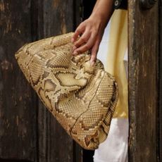 Noorie Ana carrying snake print clutch bag