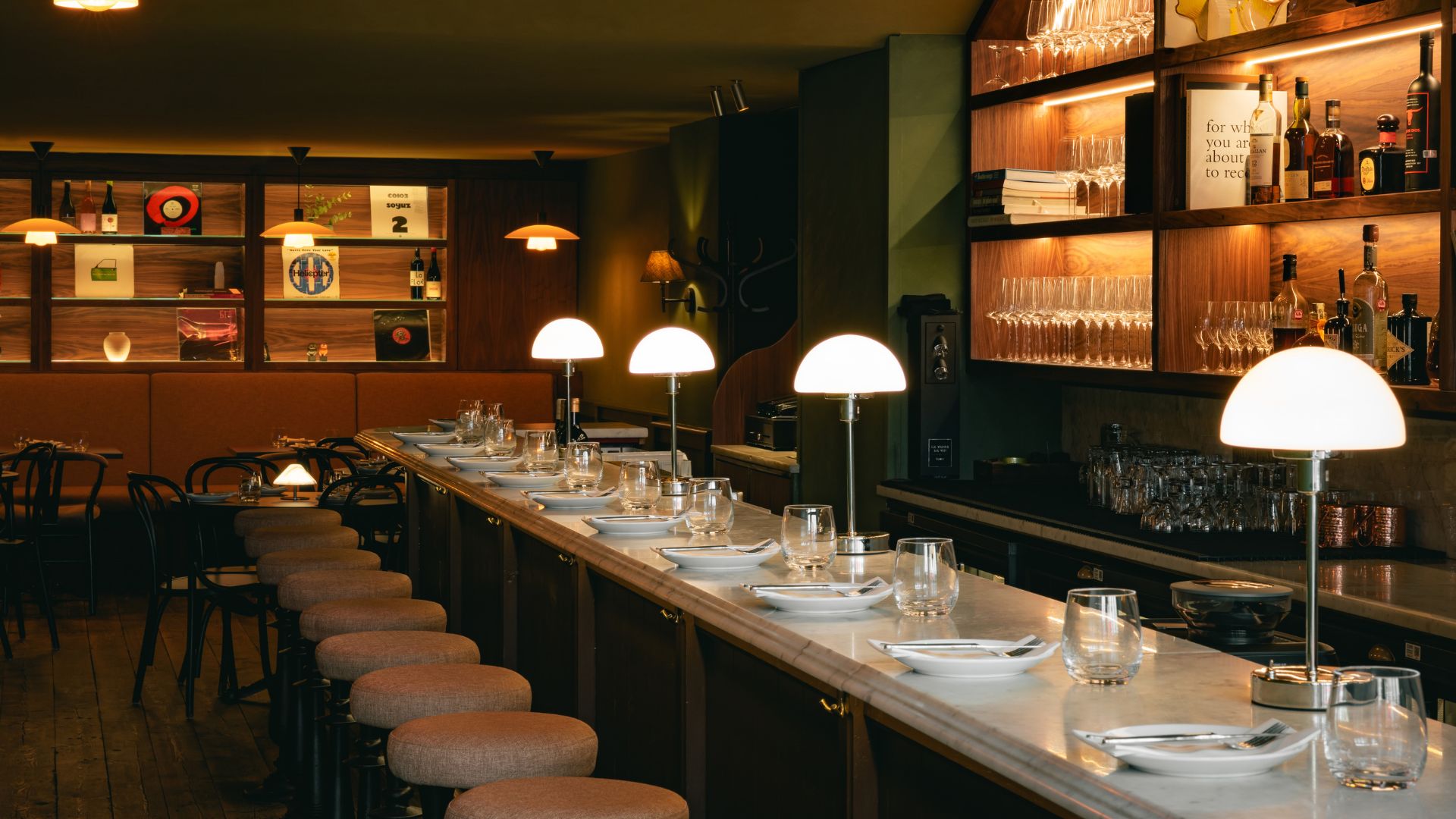 an image of the interiors at Sova, showing the counter top bar seats, and the listening bar tables