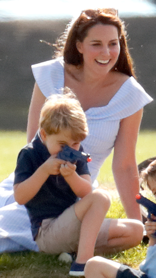 Catherine, Duchess of Cambridge looks on as Prince George of Cambridge plays with a toy gun whilst attending the Maserati Royal Charity Polo Trophy at the Beaufort Polo Club on June 10, 2018 in Gloucester, England