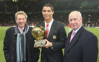Cristiano Ronaldo holds the Ballon d'Or while stood alongside Denis Law and Bobby Charlton