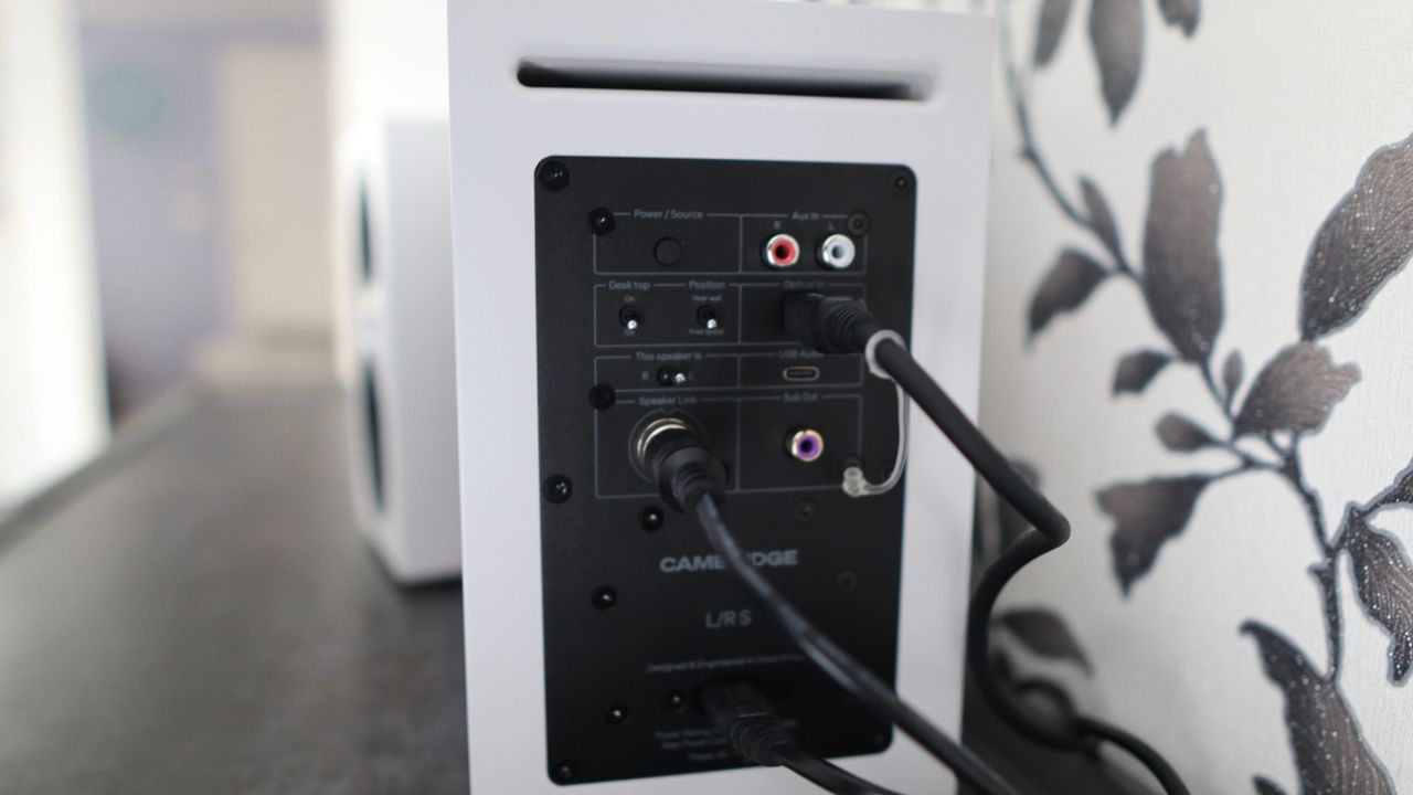 Cambridge Audio's L/R S speakers on a desk. The speakers are white with black tweeters.