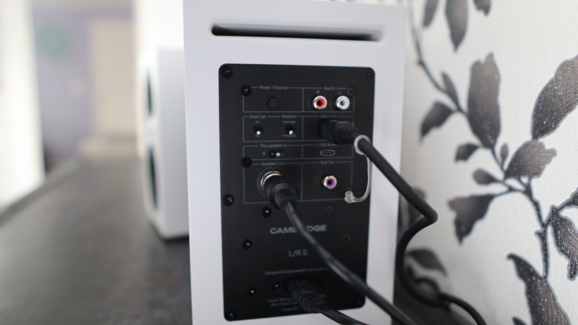 Cambridge Audio's L/R S speakers on a desk. The speakers are white with black tweeters.