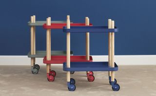 Three trolleys on wheels in grey, red and blue