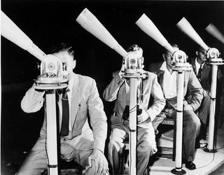 1965: Project Moonwatch volunteers in Pretoria, South Africa, one of more than 100 teams worldwide. Each telescope covered a small, overlapping portion of the sky. Smithsonian Institution Archives.