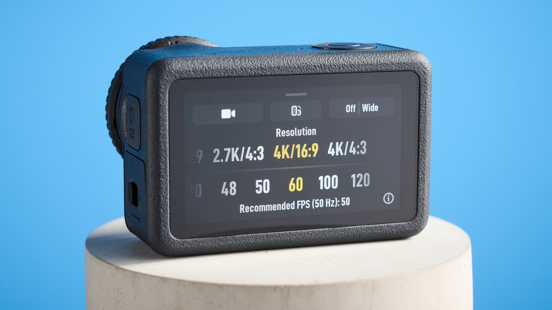 The DJI Osmo Action 6 on a stone surface with a blue background