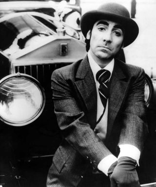Keith Moon sitting next to a Rolls Royce