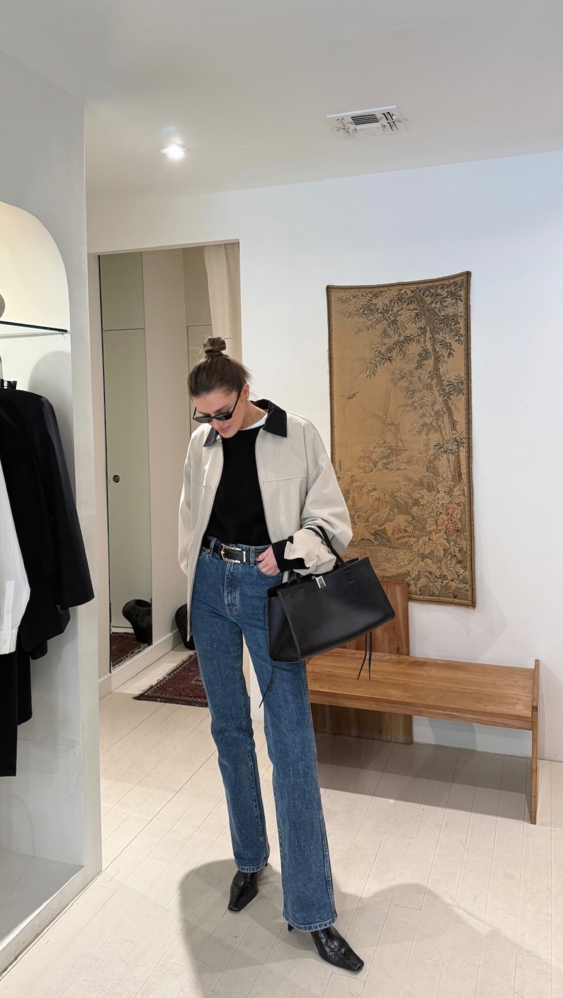 An image of @cocoschiffer wearing a barn jacket with stovepipe jeans and block heel boots.