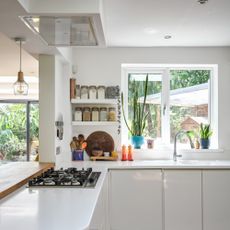 White kitchen countertops with decorative jars and plants