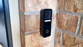 Logitech Circle View doorbell installed on a brick wall outdoors.