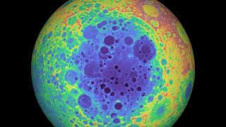 A giant orb takes up the majority of the image, bordered on either sitde by black. Its face is riddled with craters, with colors blotched throughout in vibrant blues, greens, yellows, and reds.