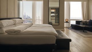 Equinox Hotels guest room featuring the Equinox Hotels Sleep System on the left, a king-size bed with pillows and a pair of duvets