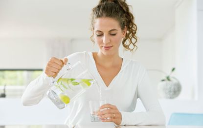 woman pouring herself a glass of water