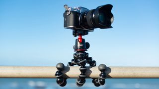 Joby gorillapod 5k attached to a horizontal pole with a blue sky behind