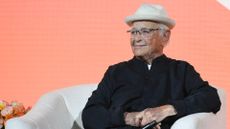 Norman Lear sitting in a white chair