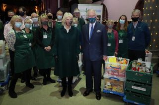 Prince Charles, Prince of Wales and Camilla, Duchess of Cornwall pose for a photo with volunteers during a visit to St. Mark's Church in Battersea on December 14, 2021