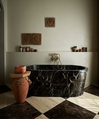 large marble black and white checkerboard bathroom floor and black marble bathtub