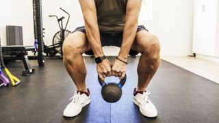 a man doing a kettlebell squat