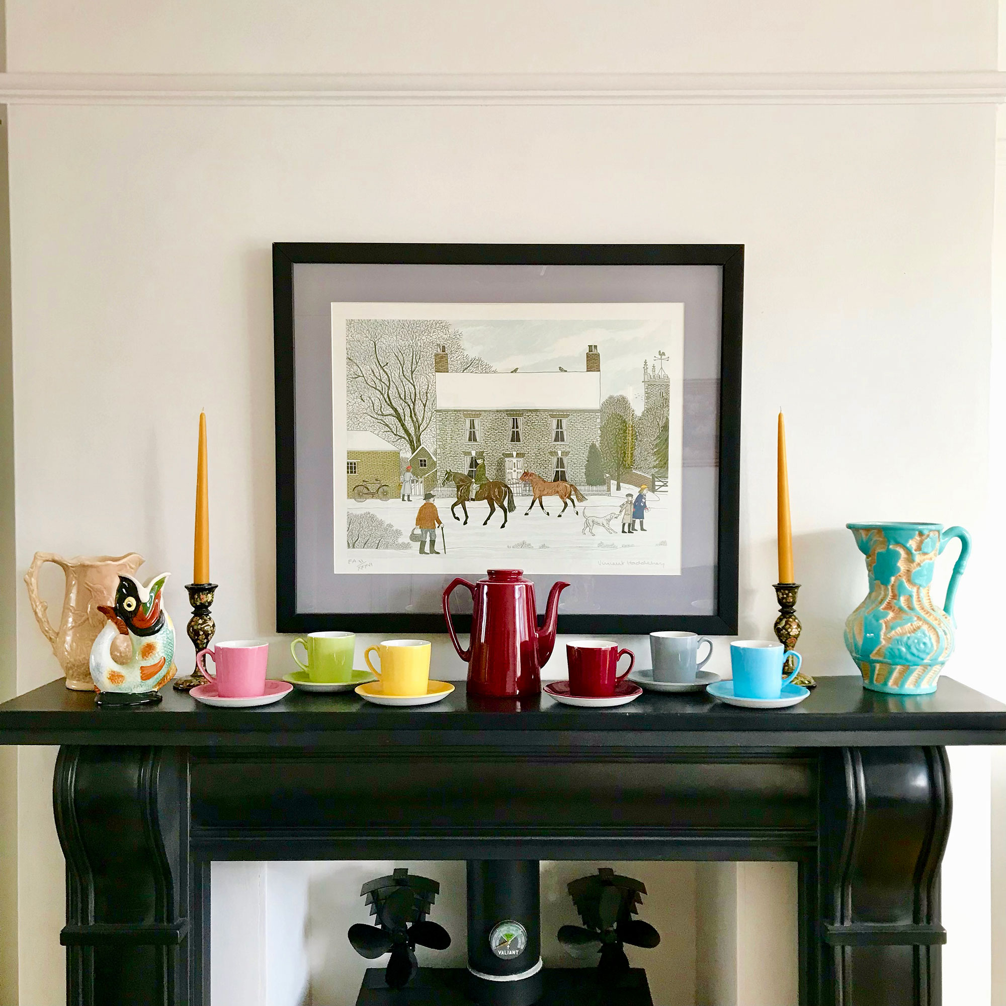 Fireplace mantlepiece with colourful tea set, vases and winter scene painting