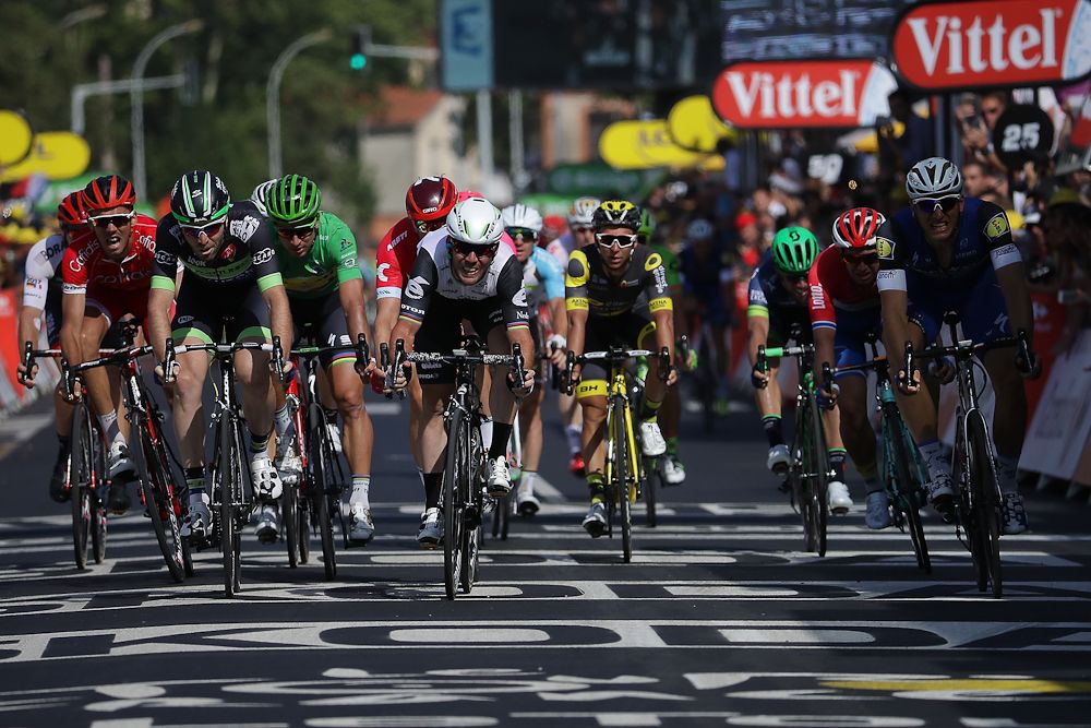 The sprinters cross the line at the finish of stage 6.