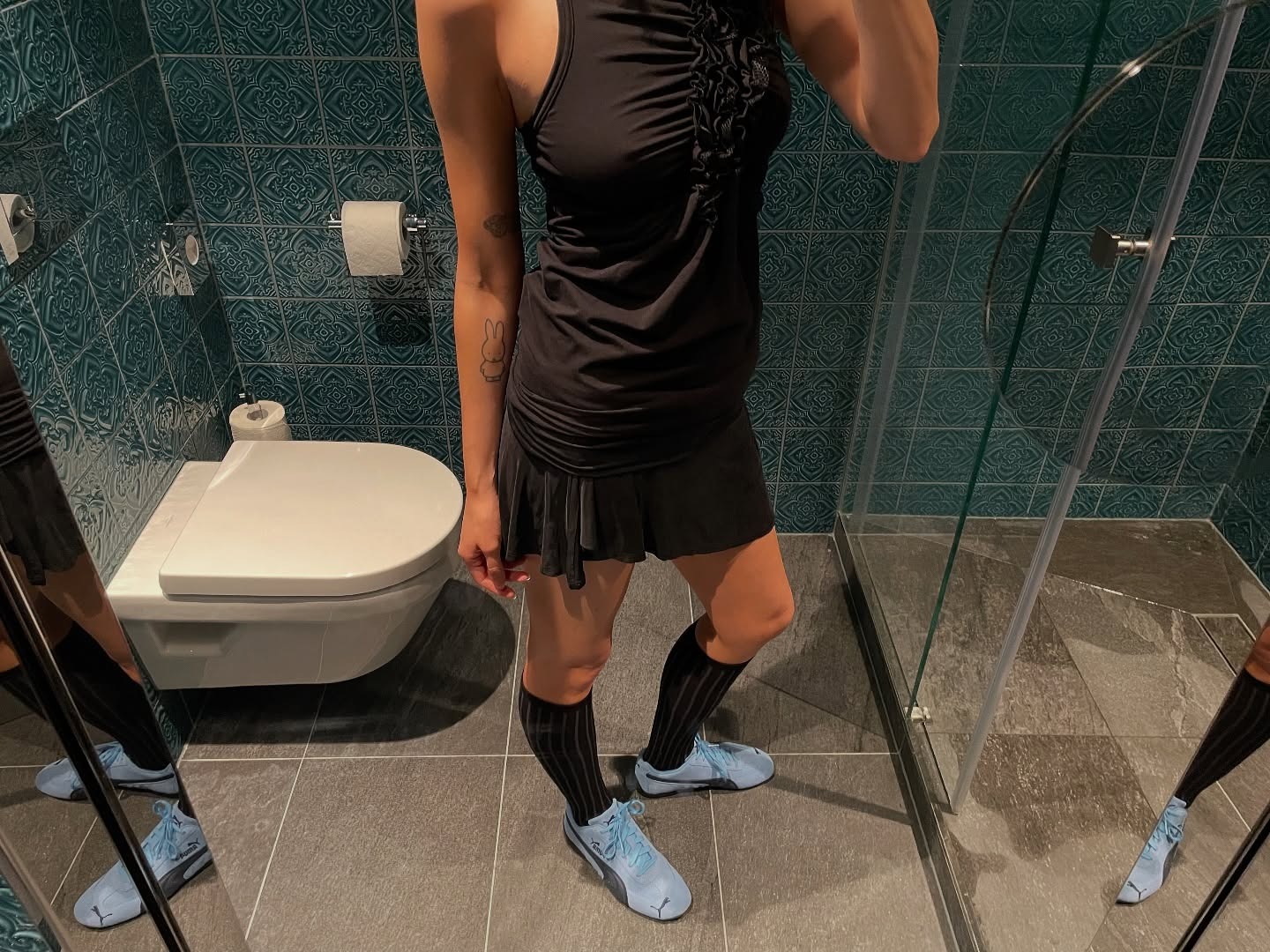 Influencer Susie Garvie wears blue Puma speedcat sneakers.
