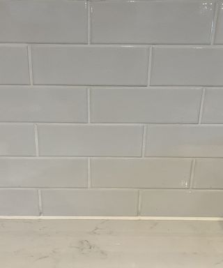 Finished white metro tiles backsplash on white worktop