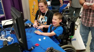 A young disabled boy playing video games with some adaptive controllers