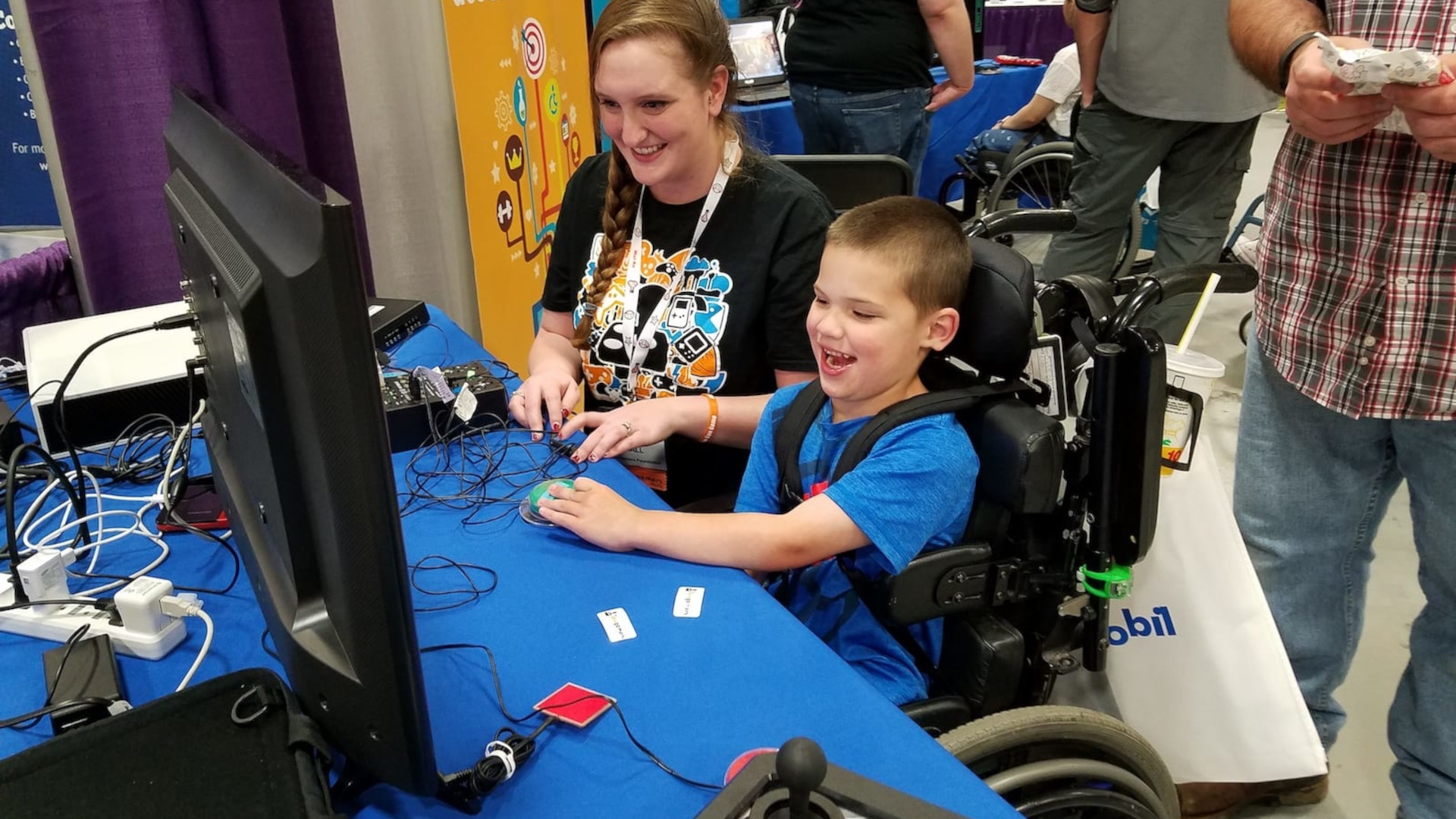 A young disabled boy playing video games with some adaptive controllers