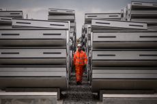 A construction worker walks between concrete tunnel lining ring segments at an HS2 site in West Hyde, England