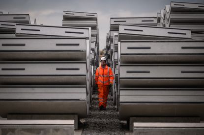 A construction worker walks between concrete tunnel lining ring segments at an HS2 site in West Hyde, England