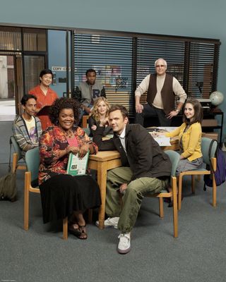 a promo shot of the cast of Community sitting in a class room