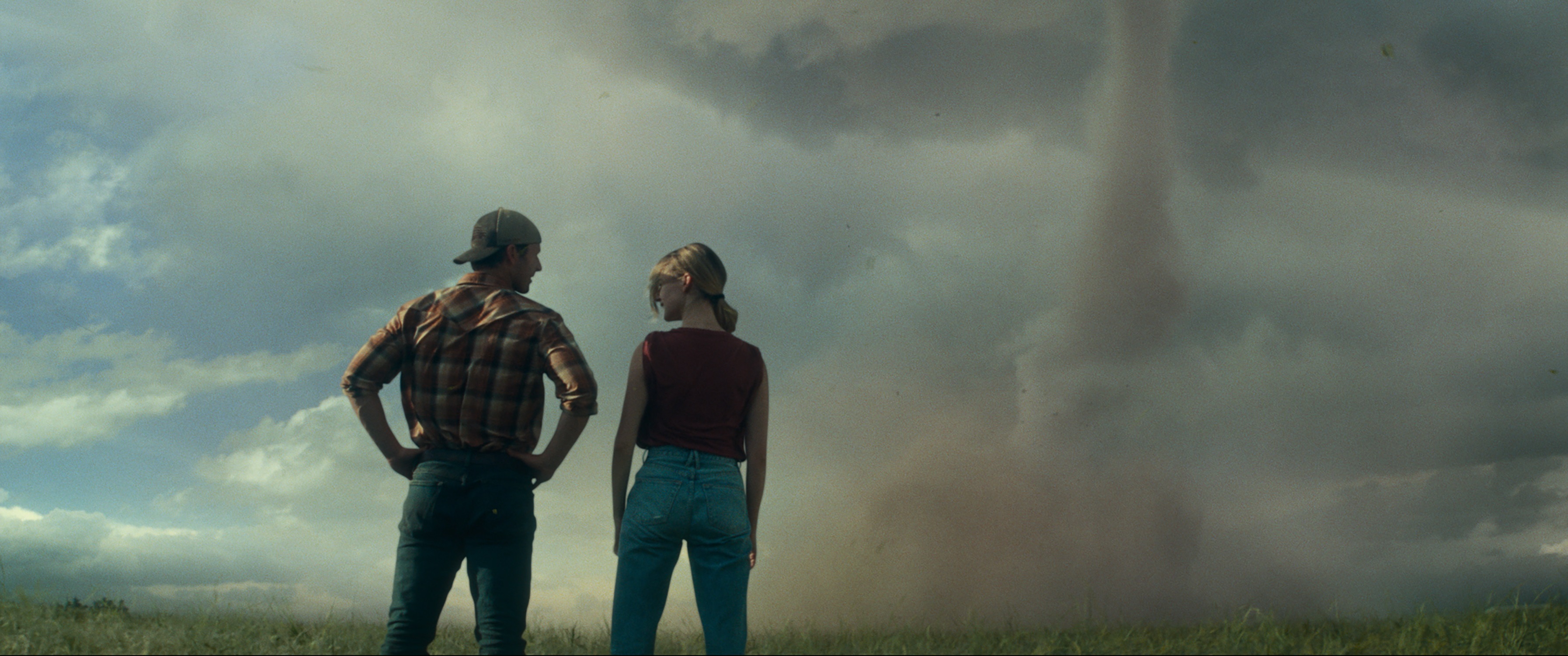 The main characters of Twisters look at a twister.