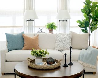 white sofa with pastel throw pillows and white lamps