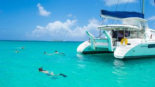 A yacht with scuba divers is pictured in stunning blue waters of Nassau