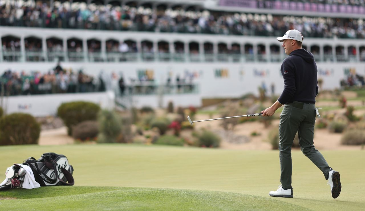 Justin Thomas lifts his putter to the crowd at the 16th hole at the Waste Management Phoenix Open