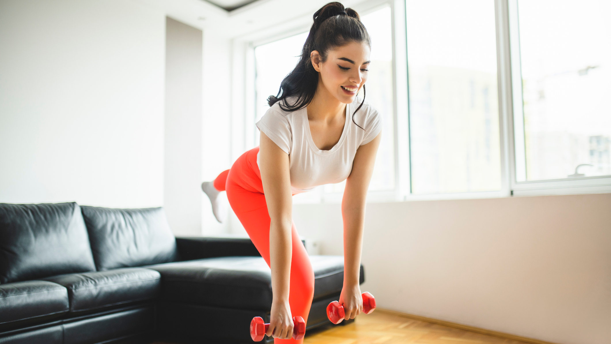 Woman exercises with dumbbells in a domestic setting