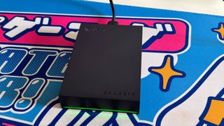 The Seagate Game Drive for Xbox on a colorful desk mat.