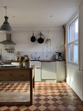 kitchen with sage green cabinets and brown checkerboard floor, wood island