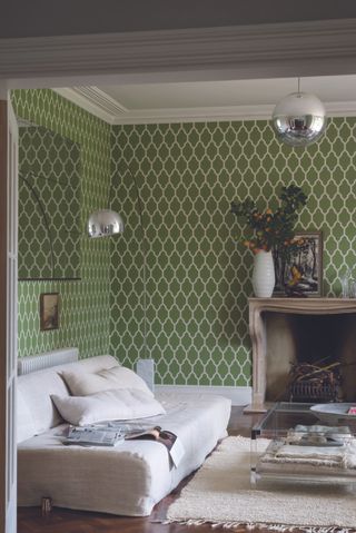 A green living room using Farrow and Ball's Tessella wallpaper decor