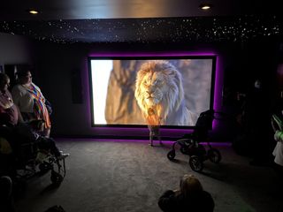 A child plays with a lion on a projection screen with technologies provided by Snap One.