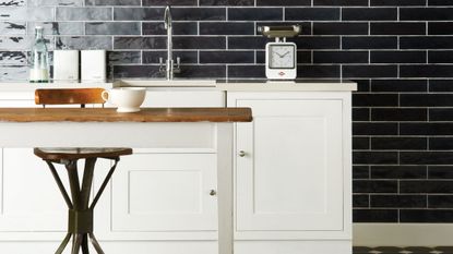 kitchen with monochrome scheme, white cupboards and black metro tiles