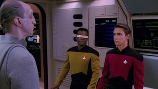 The Traveler, Geordi La Forge and Wesley Crusher standing in the starships control room. Wesley is now wearing a red Starfleet uniform.