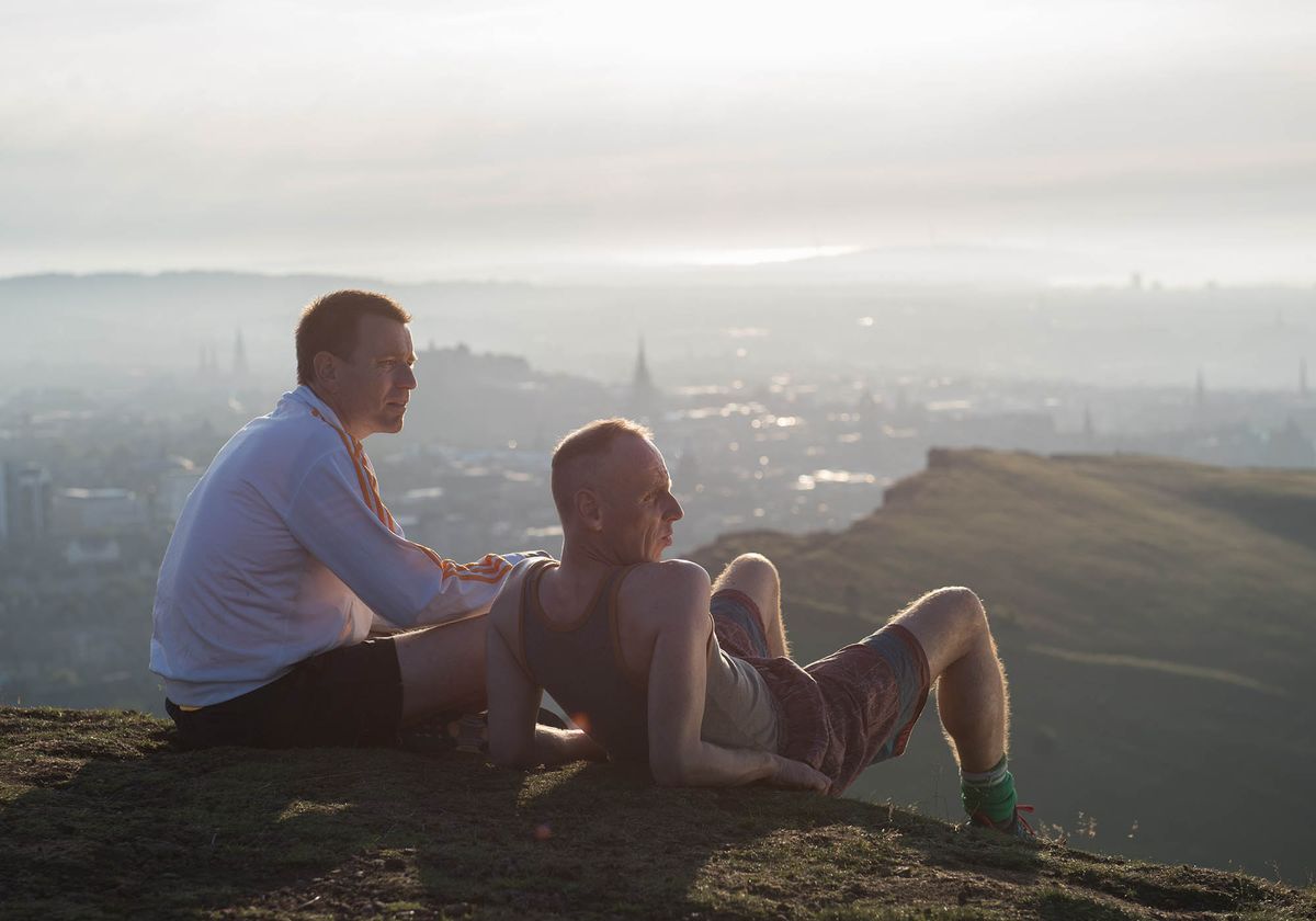 Ewan McGregor and Ewan Bremner set on a hill above Edinburgh admiring the view