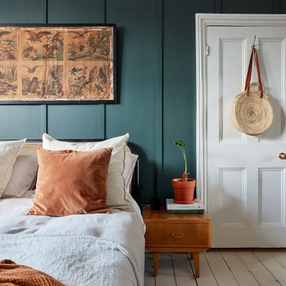 Teal bedroom with wooden bedside table and linen bedding