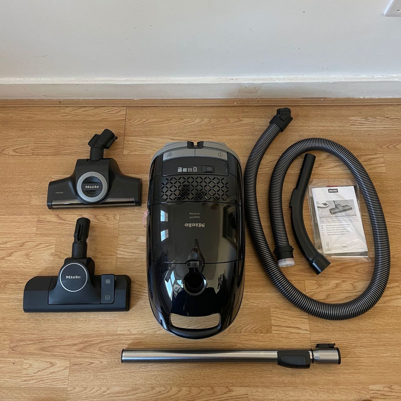 Miele Guard M1 Cat &amp; Dog components laid out on laminate flooring