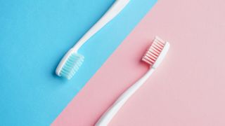 blue and pink toothbrushes on blue and pink background