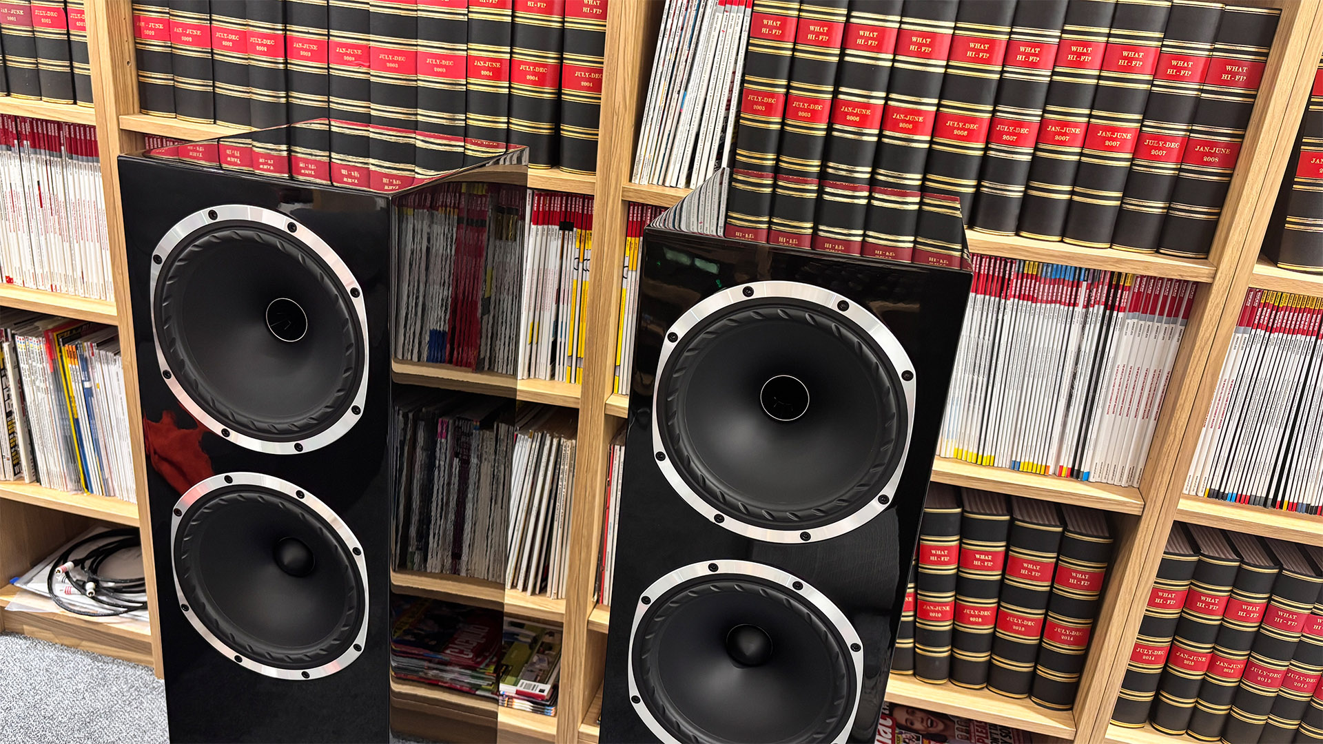 Fyne Audio F502S floorstanding speakers in front of bookcase slight downward view