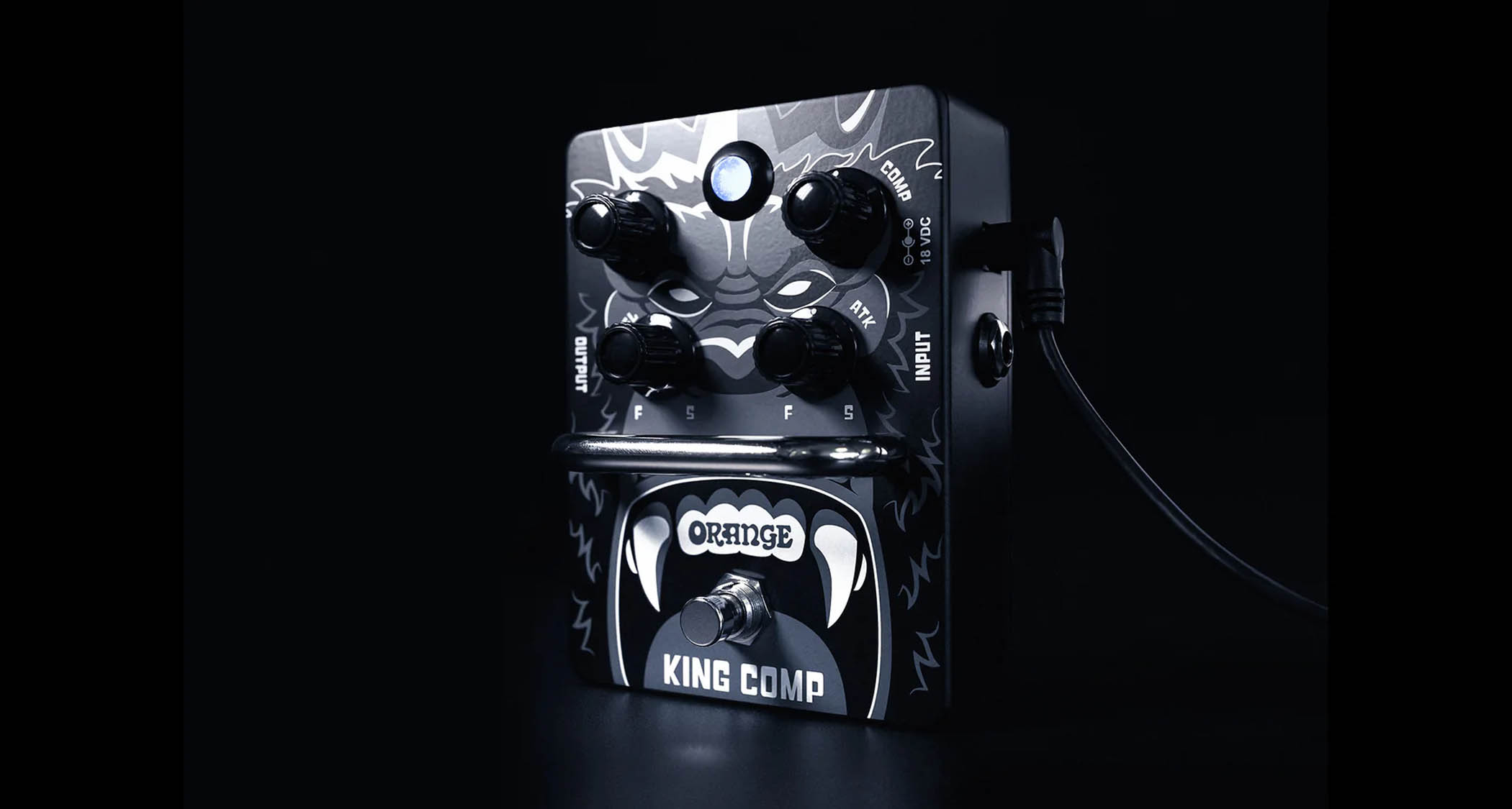 Orange Amps King Comp compressor pedal, photographed at an angle in a darkened room.