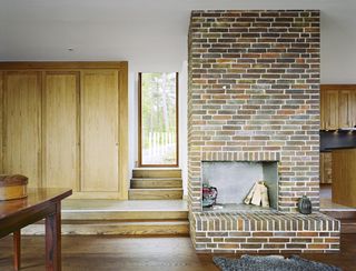 A detail of the living space in Villa Arkö shows the brick fireplace that goes all the way to the ceiling.