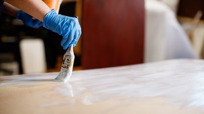 painting a kitchen countertop white with a paintbrush