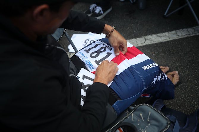 Travis McCabe of the USA National Team pins on his numbers before stage 5 of the 2019 Tour of California